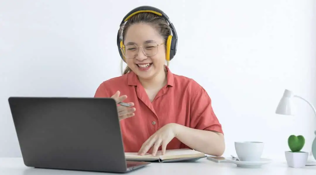 a woman with headphones in front of the laptop