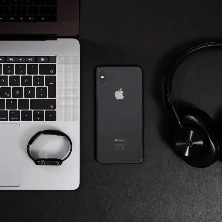 laptop, cellphone and headphones on the desk